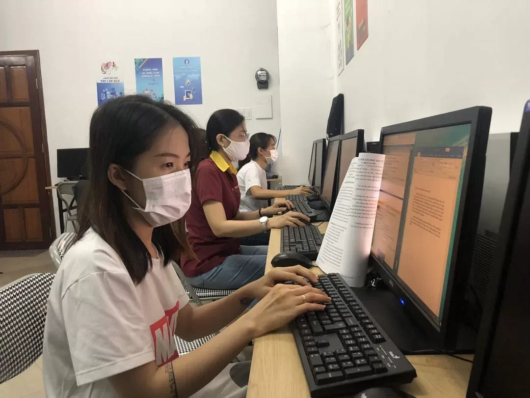Ba học viên đeo khẩu trang đang sử dụng máy tính trong phòng học của trung tâm Edusa